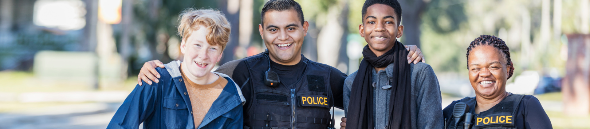 police man in kevlar vest poses with three children