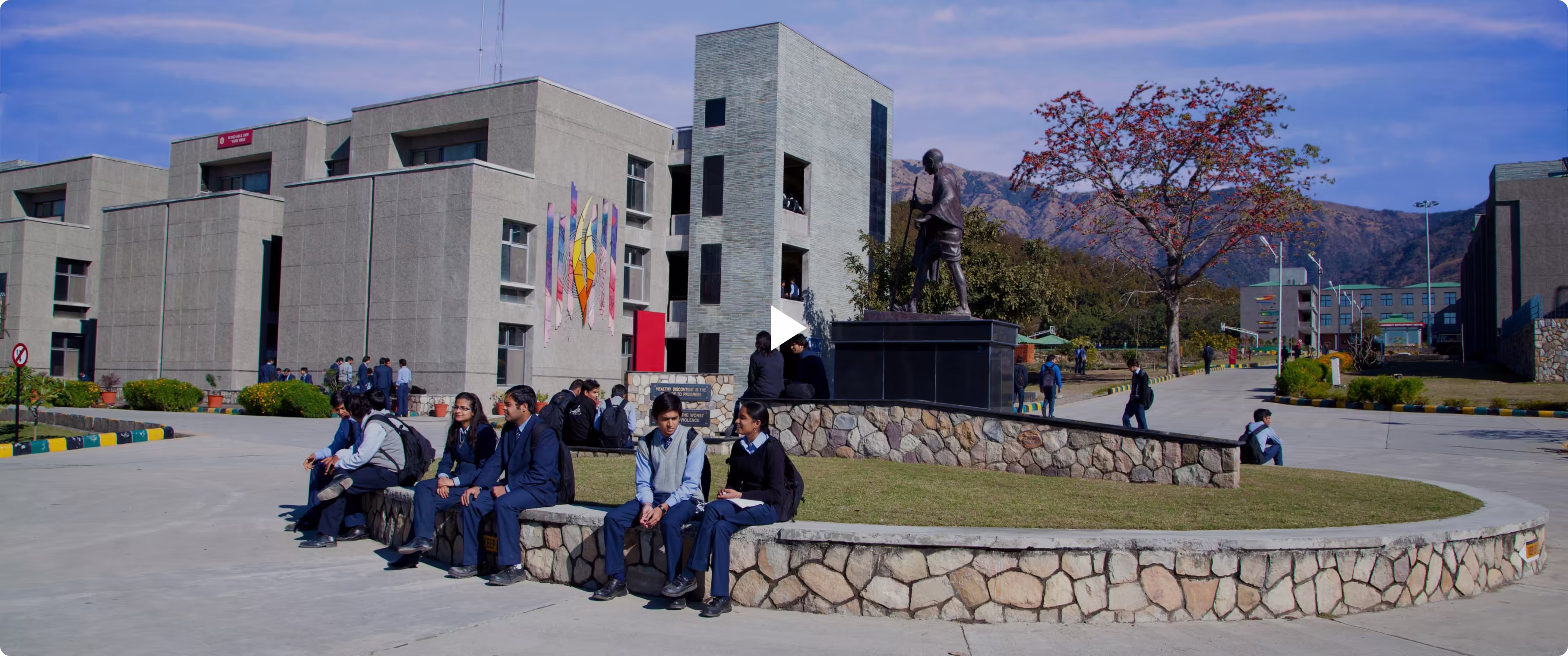 Students sitting together in outdoor space at National University location.